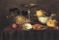 A silver dish with an oyster and a crab, a walnut, white grapes, a silver 